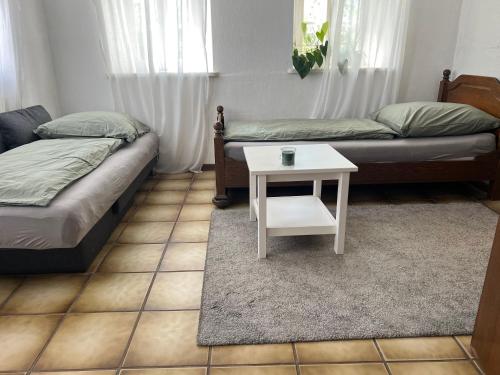 uma sala de estar com duas camas e uma mesa em Zimmer auf dem Scheuerhof em Wittlich