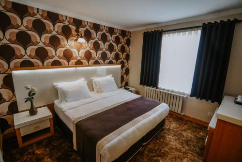 um quarto de hotel com uma cama grande e uma janela em Horon Hotel em Trebizonda