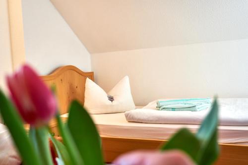 a small bedroom with a bed with pink flowers at Haus Strandeck in Zingst