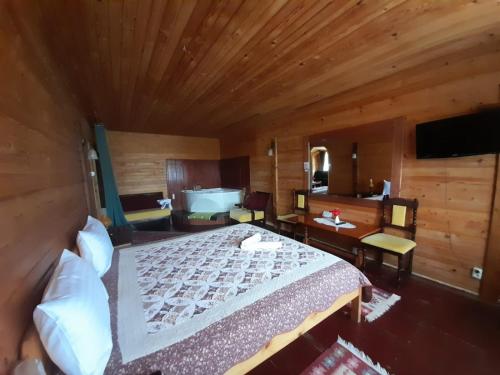 a bedroom with a large bed and a bathroom at Vila Riki in Borsec