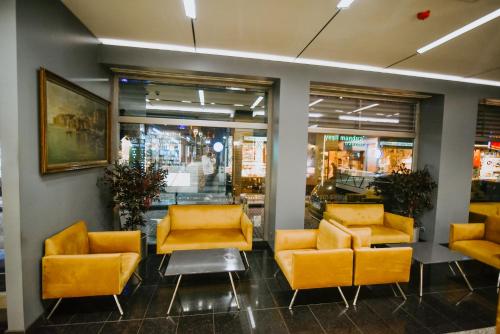 a lobby with yellow chairs and tables in a store at Horon Hotel in Trabzon