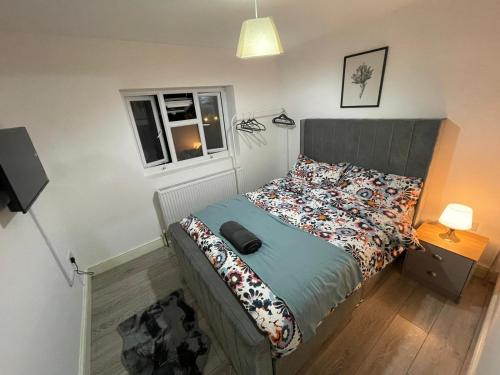 1 dormitorio con cama y ventana en Sweet 7 bedroom Mansion London en Ilford