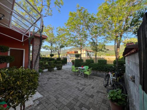 a patio with a table and chairs in a yard at Guesthouse Koleci - Mrizi Zanave in Fishtë