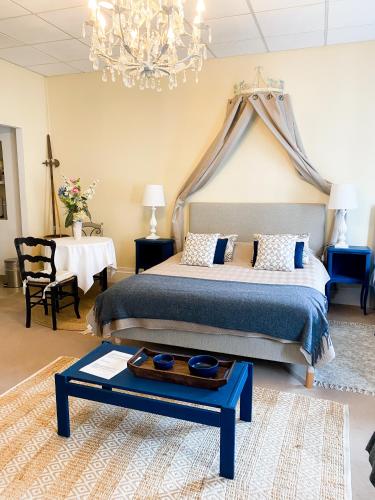 - une chambre avec un lit, un lustre et une table dans l'établissement Chambres D'Hôtes La Villa Aliénor, aux Andelys