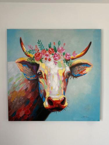 a painting of a cow wearing a flower crown at Boutique Hotel Bellevue B&B am Brienzersee Iseltwald Interlaken in Iseltwald