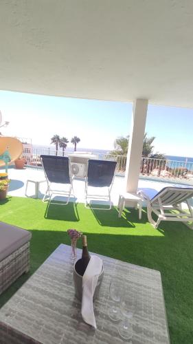 a patio with a table with a bottle and glasses at Aeromar Beach Hotel in Faro