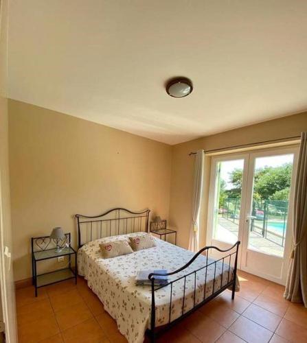 une chambre avec un lit et une grande fenêtre dans l'établissement Tranquillité champêtre en famille, à Thénac