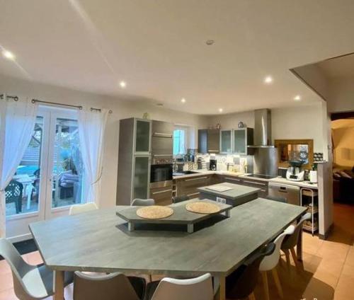 une grande cuisine avec une grande table et des chaises dans l'établissement Tranquillité champêtre en famille, à Thénac