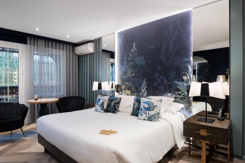 a bedroom with a large white bed with a blue wall at LA CHENEAUDIÈRE - Hôtel Spa - Relais & Châteaux - Restaurant étoilé in Colroy-la-Roche