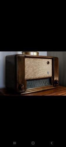 an old radio sitting on top of a wooden table at San Marcellino House in Marigliano