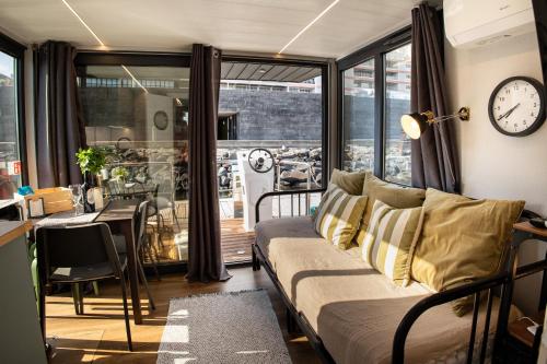 a living room with a couch and a clock on the wall at The Homeboat Company Ponta Delgada-Açores in Ponta Delgada