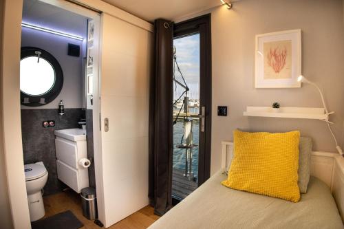 a bedroom with a bed with a yellow pillow at The Homeboat Company Ponta Delgada-Açores in Ponta Delgada