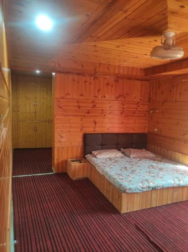 um quarto com uma cama num chalé de madeira em Habib gust house em Tangmarg
