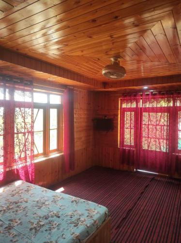 um quarto com duas janelas e uma cama. em Habib gust house em Tangmarg