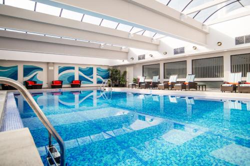 een groot zwembad met blauw water in een gebouw bij Delta Hotels by Marriott San Jose Aurola in San José