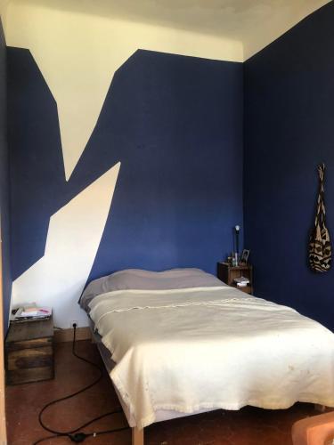 une chambre avec un lit avec un mur bleu dans l'établissement El Laberinto, à Marseille