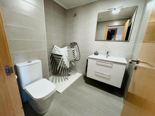 a bathroom with a toilet and a sink and a mirror at Apartamento Playa Oliva in Oliva