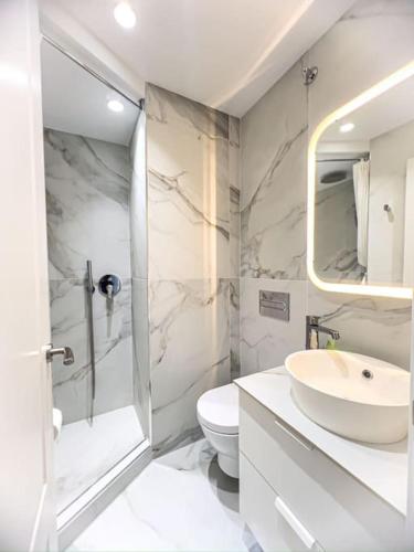 a white bathroom with a sink and a toilet at Apartamento Andrea con piscina in Marbella