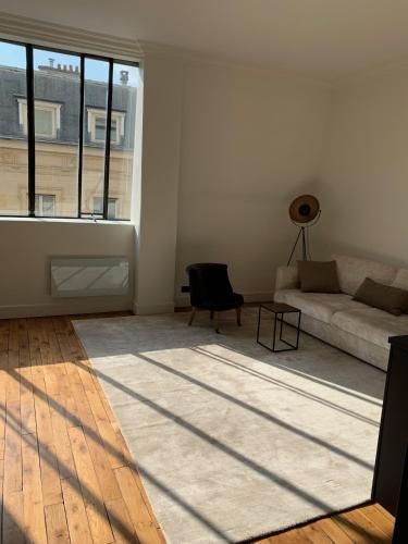 un salon avec un canapé et une grande fenêtre dans l'établissement Superbe appartement Tour Eiffel, à Paris