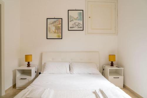 ein Schlafzimmer mit einem weißen Bett und zwei Nachttischen in der Unterkunft Residenza "il sogno di Geppino" al centro di Capri in Capri