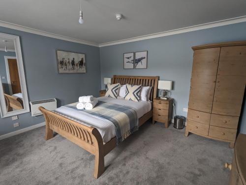 1 dormitorio con 1 cama grande con marco de madera en Sithean Beag, en Portree