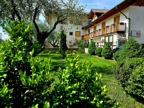 a house with bushes in front of a yard at Antico Fienile Agritur in Mezzocorona