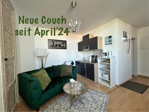 uma sala de estar com um sofá verde e uma mesa em Ostseeland em Barth