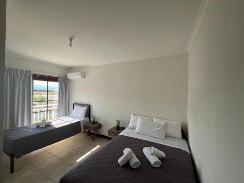 a hotel room with two beds and a window at Pegasus House in Kórinthos