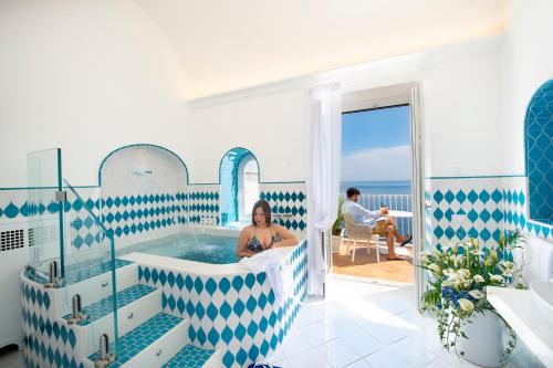 a woman sitting in a hot tub in a room at Villa Francesco Luxury Suites in Positano