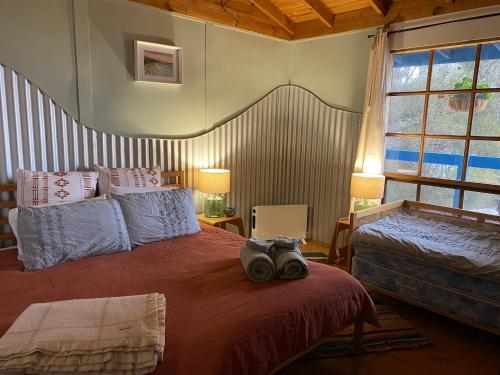 a bedroom with two beds and a large window at Sheoak Lodge in Penneshaw