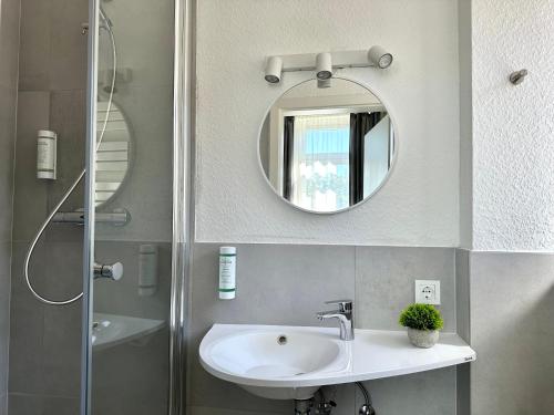 a bathroom with a sink and a mirror at City Hotel Hameln in Hameln