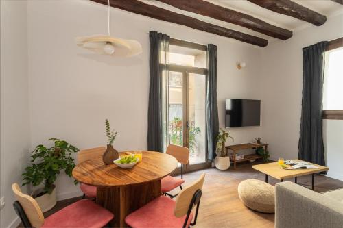 a living room with a wooden table and a dining room at Comfy Stay Barcelona Cathedral in Barcelona