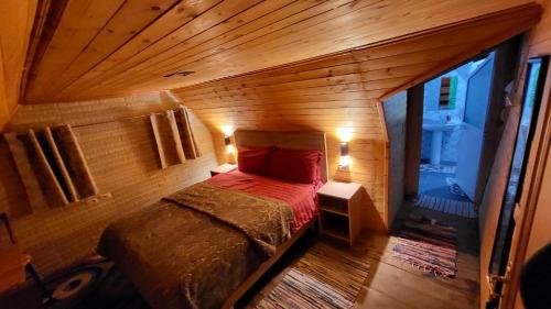 ein Schlafzimmer mit einem Bett in einem Holzzimmer in der Unterkunft Bujtina Pllumi Theth in Theth