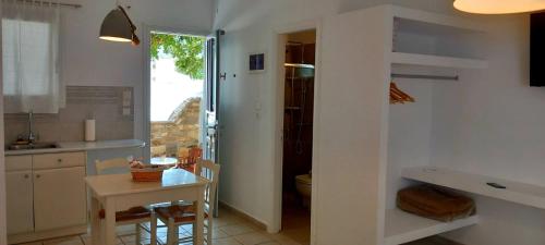 a kitchen with a table and a small table and a kitchen with a sink at Anixis Studios Aliki Paros in Aliki