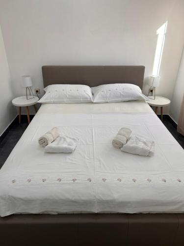 a large white bed with two pillows on it at Apartman Daisy in Slatine