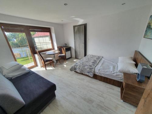 a bedroom with a bed and a desk and a window at Holiday House in Krynica Morska