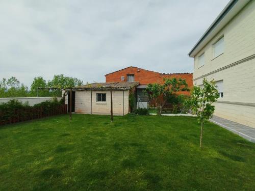 a yard with a house and a building at Miradoralaribera Chalet rural in Alcoba de la Ribera