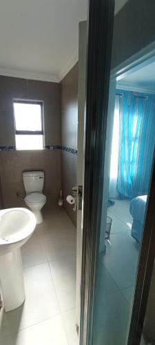 a bathroom with a toilet and a sink at eSunvalley Guest House in Roodepoort