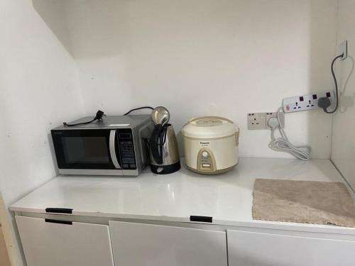 コタキナバルにあるKiena Homestay Uuc 2bilikの電子レンジ、トースター付きのキッチンカウンター