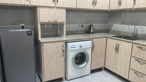 uma cozinha com uma máquina de lavar roupa e um lavatório em ماجيك سويت الفحيحيل Magic Suite ALFahaheel em Kuwait