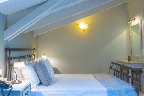 a bedroom with a bed with a blue bed frame at Arethousa Hotel in Katakolon