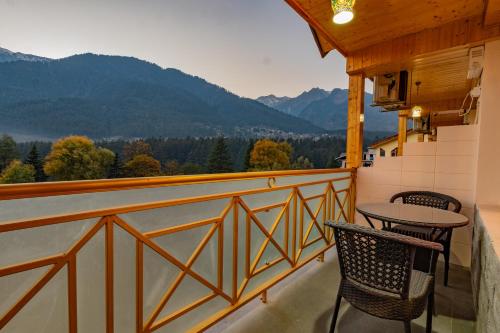 a balcony with a table and two chairs and a view at Hill Rive Resort Near Mall Road in Manāli