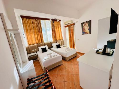 ein Hotelzimmer mit 2 Betten und einem TV in der Unterkunft Oskar Hotel in Sarandë