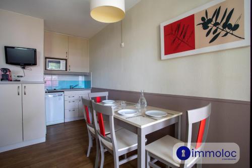 une cuisine et une salle à manger avec une table et des chaises dans l'établissement Air-conditioned studio in Mandelieu with swimming pool, à Mandelieu-la-Napoule