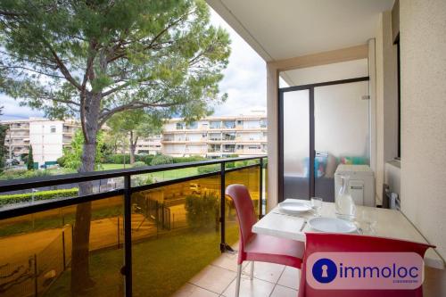 une pièce avec une table et un balcon avec un arbre dans l'établissement Air-conditioned studio in Mandelieu with swimming pool, à Mandelieu-la-Napoule