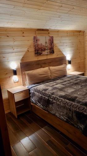 a bedroom with a bed in a wooden cabin at Bujtina Pllumi Theth in Theth