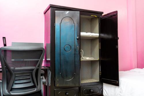 a wooden cabinet with a chair next to a bed at EG Studio-Carrefour ISTAMA-Sable Bonamoussadi-0m from Road in Douala