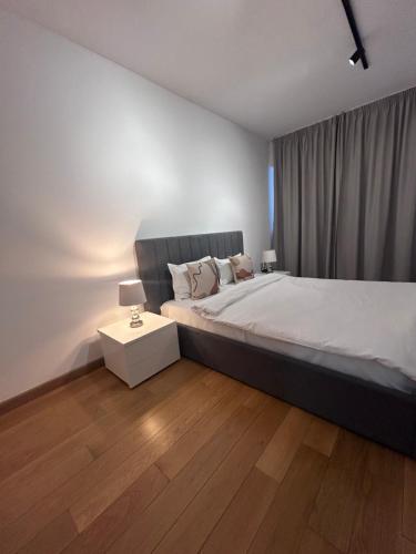 a bedroom with a large bed and a night stand at 365 Apartments in Bucharest in Bucharest