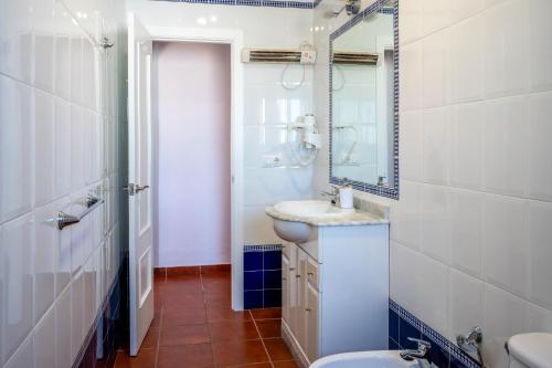 a bathroom with a sink and a toilet and a mirror at Casas Rurales Pericón in Conil de la Frontera