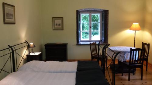 a bedroom with a bed and a table and a window at Zamek Rynkówka in Rynkówka